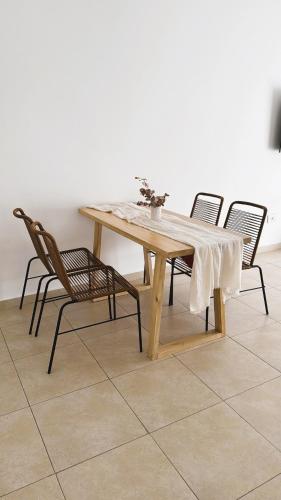 a wooden table with four chairs around it on a tile floor at Departamento en pleno centro de Corrientes in Corrientes