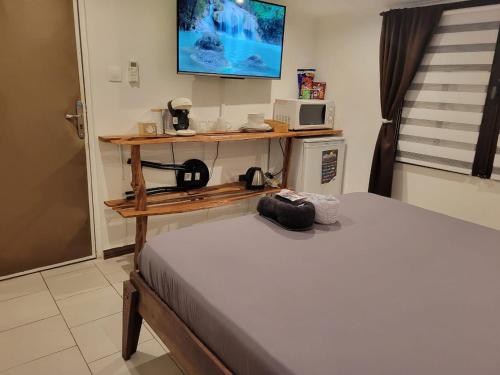 a room with two beds and a tv on the wall at Hudace in Saint-Laurent du Maroni