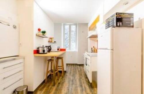 a small kitchen with a table and a refrigerator at Moonlight in Chambéry