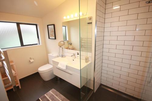 a bathroom with a sink and a toilet and a shower at Tempest on Wanaka in Wanaka