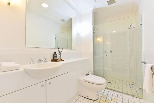 a white bathroom with a sink and a toilet at Villa 3br Bella Vista Villa located within Cypress Lakes Resort in Pokolbin