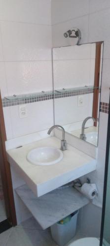 y baño con lavabo y espejo. en Suite Grande Rio en Duque de Caxias
