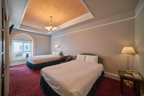 a hotel room with two beds and a window at The Bedford Regency Hotel in Victoria