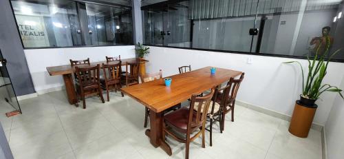 Un restaurante con mesas y sillas de madera en una sala. en Hotel Phizalis, en São Caetano do Sul