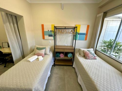 a bedroom with two beds and a window at Studio Bena 2 - single bed - próx Shopping Iguatemi in Campinas