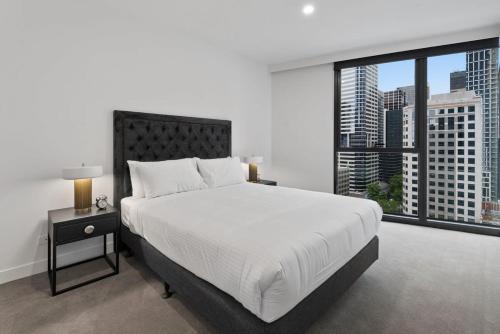1 dormitorio con cama grande y ventana grande en Executive 2-Bed Apartment with a BBQ, en Melbourne