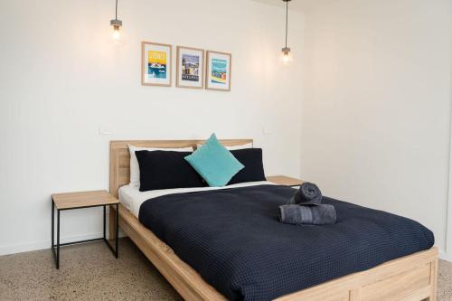 a bedroom with a large bed with blue pillows at Apostle Escape in Port Campbell