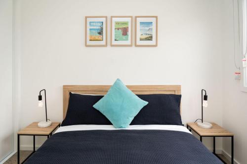 a bedroom with a bed with a blue pillow on it at Apostle Escape in Port Campbell