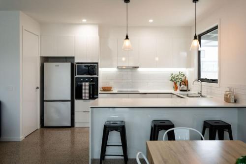 a white kitchen with a counter and a refrigerator at Apostle Escape in Port Campbell