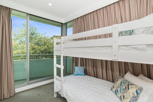 a bedroom with two bunk beds and a balcony at Warm Waves - Beach Pool Home in Glenelg