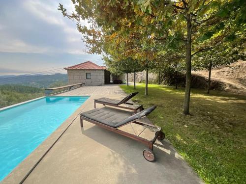 a bench sitting next to a swimming pool at Casa da Prelada in Amarante