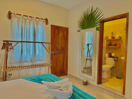 a bedroom with a bed and a bathroom with a mirror at Hotel Jaiba Mahahual - Adults Only in Mahahual