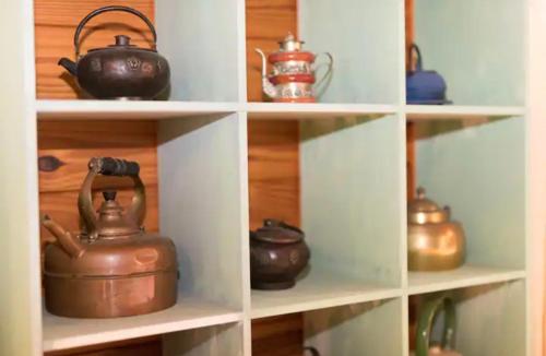 a bunch of pots and pans on shelves at Krishna Farm Retreat in Coolabine