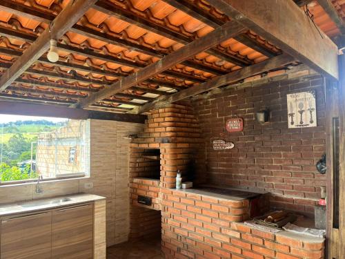 um forno de tijolos numa cozinha com uma parede de tijolos em sitio dona cida e joze em Extrema