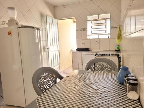 a kitchen with a table and a refrigerator at Lugarzin2 - Casa Privada - Garagem Compartilhada in Vitória da Conquista