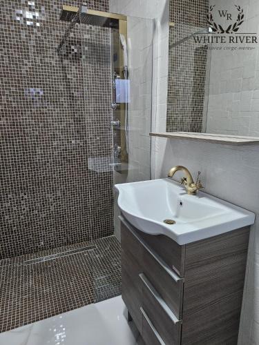 a bathroom with a sink and a shower at Pensiunea WhiteRiver Adults Only-Self check-in in Câmpulung Moldovenesc