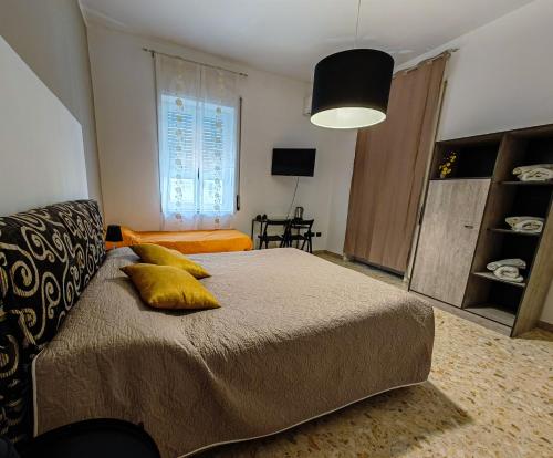 a bedroom with a bed with yellow pillows on it at Ament's B&B in Siracusa