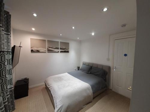 ein Schlafzimmer mit einem Bett in einem weißen Zimmer in der Unterkunft J's House in Nottingham