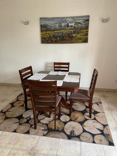 a dining room table and chairs on a rug at Kisumu 3 bedroom Apartment Elegant in Kisumu