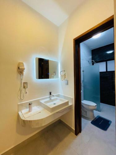 a bathroom with a sink and a toilet and a mirror at CASA SAN AGUSTÍN #4 in Puerto Escondido