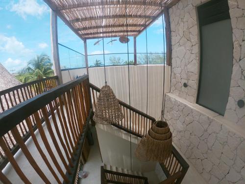 a balcony with two hanging hammocks on it at Casa Hood By the Sea in Holbox Island