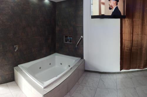Hostal Zafiro في Sangolquí: حمام مع بانيو وصورة رجل