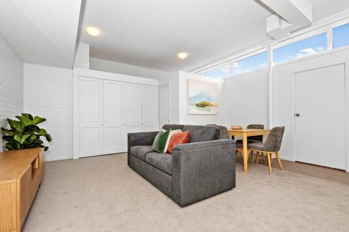 a living room with a couch and a table at Beach Retreat Apartment A in Frankston