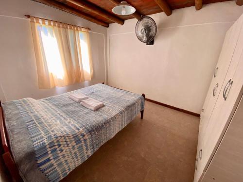 a bedroom with a bed with a blue plaid blanket at Los Cardenales in San José