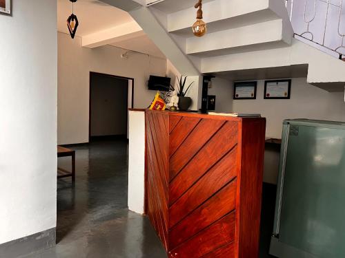 a kitchen with a wooden cabinet in a room at The Lovina Place in Mount Lavinia