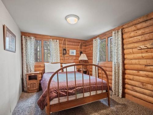 - une chambre avec un lit dans une pièce dotée de murs en bois dans l'établissement Lake Flora Cabin, à Leadville