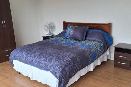 a bedroom with a bed with a purple comforter at Casa en cerro, playa, piscina y vista insuperable in El Convento