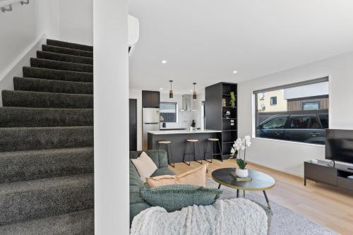 a living room and kitchen with a staircase and a living room at Peaceful Elegant Designated Park King Bed in Christchurch