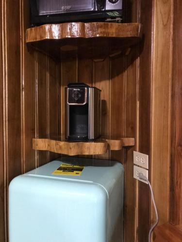 a refrigerator with a microwave on top of it at Tropical Magnolia in Hellgate