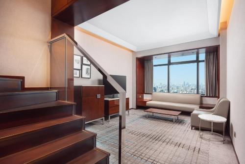 Habitación con escalera, sofá y ventana en Renaissance Shanghai Zhongshan Park Hotel, en Shanghái