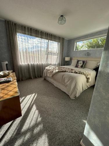 a bedroom with a large bed and a window at Omara-more in Omarama