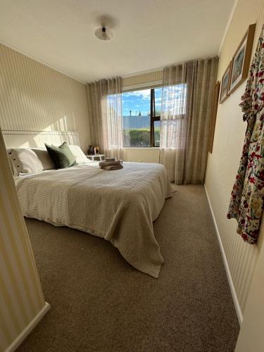 a bedroom with a large bed and a window at Omara-more in Omarama