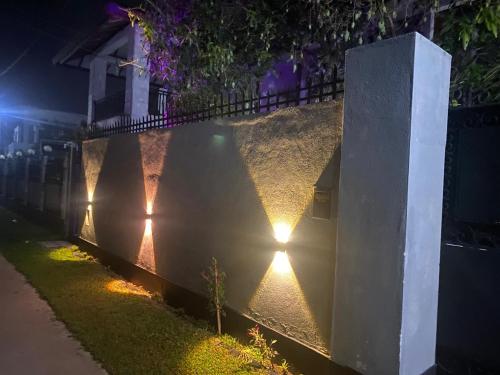 Una fila de luces en una pared por la noche en Rose Villa Accommodation, en Seeduwa