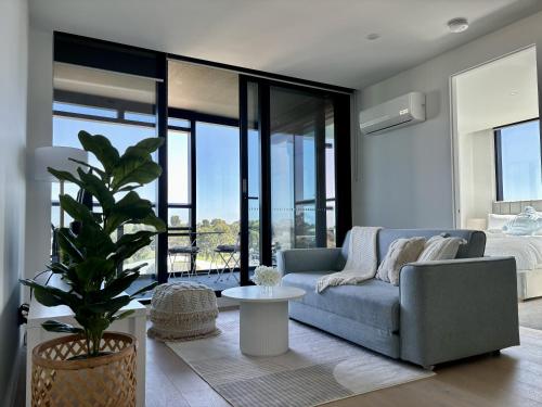a living room with a couch and a table at Skygarden Luxury Condo in Glen Waverley