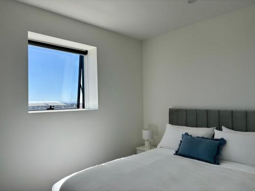 a bedroom with a white bed and a window at Skygarden Luxury Condo in Glen Waverley