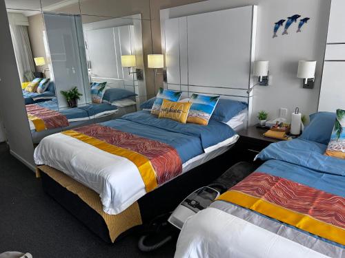 a hotel room with two beds and a mirror at Stay in the heart of Surfers in Gold Coast