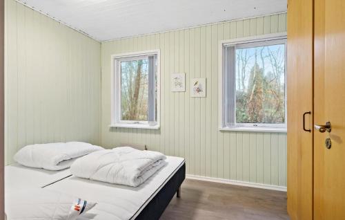 two beds in a room with two windows at 3 Bedroom Pet Friendly Home In Højslev in Højslev