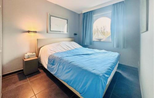 een slaapkamer met een bed en een raam met blauwe gordijnen bij Nice Apartment In Bredene With Wifi in Bredene