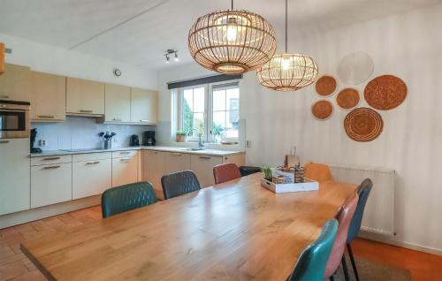eine Küche und ein Esszimmer mit einem Holztisch und Stühlen in der Unterkunft Stunning Home In Makkum With Wifi in Makkum