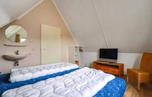 een slaapkamer met een bed, een wastafel en een spiegel bij Stunning Home In Makkum With Wifi in Makkum