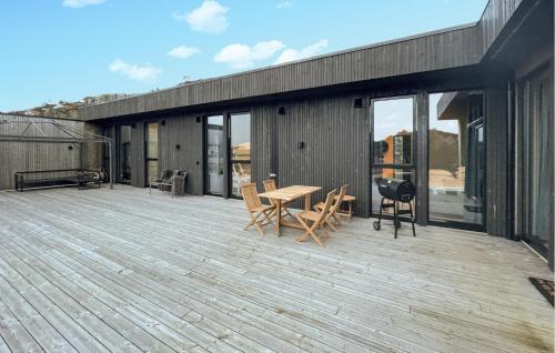 une terrasse en bois avec une table et des chaises dessus dans l'établissement 3 Bedroom Lovely Home In Lindesnes, à Svenevik