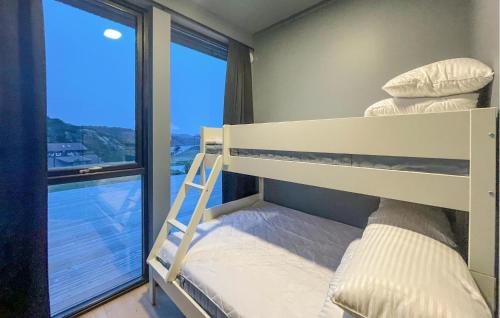 łóżko piętrowe w pokoju z dużym oknem w obiekcie Lovely Home In Lindesnes With Kitchen w mieście Svenevik