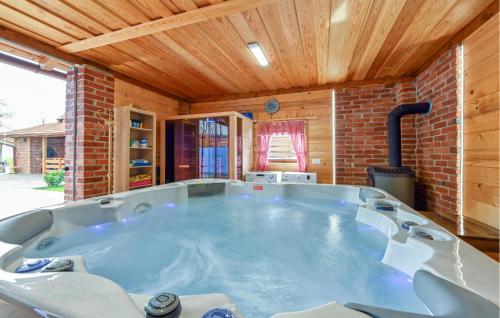 a large hot tub in a room with a brick wall at Lovely Home In Vinogradi Ludbreski in Ludbreg
