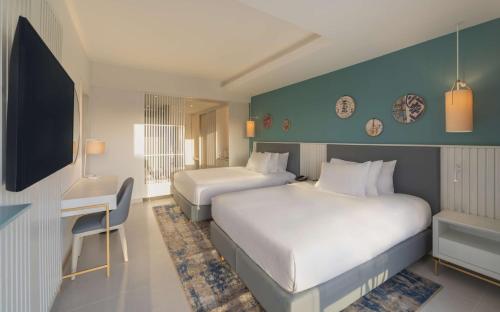 a hotel room with two beds and a desk at Hilton Skanes Monastir Beach Resort in Monastir