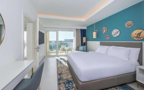 a bedroom with a white bed and a blue wall at Hilton Skanes Monastir Beach Resort in Monastir