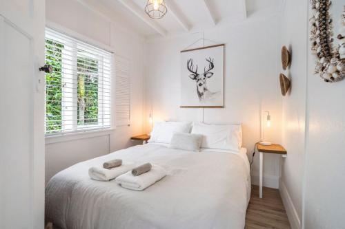 En eller flere senge i et værelse på The French Cottage by Waiheke Pure